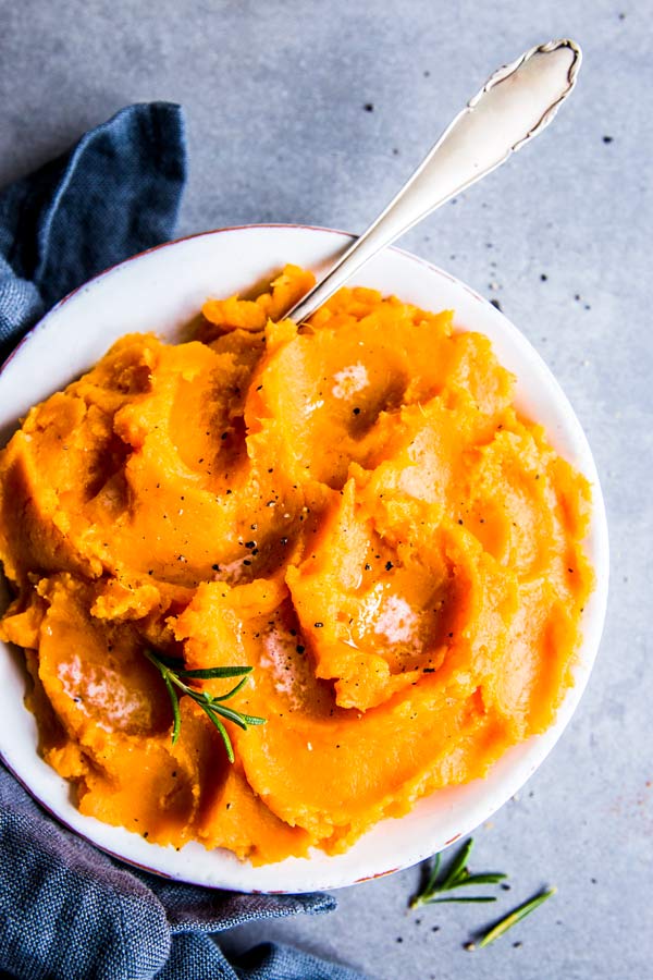 honey butter mashed sweet potatoes on a white plate with a spoon