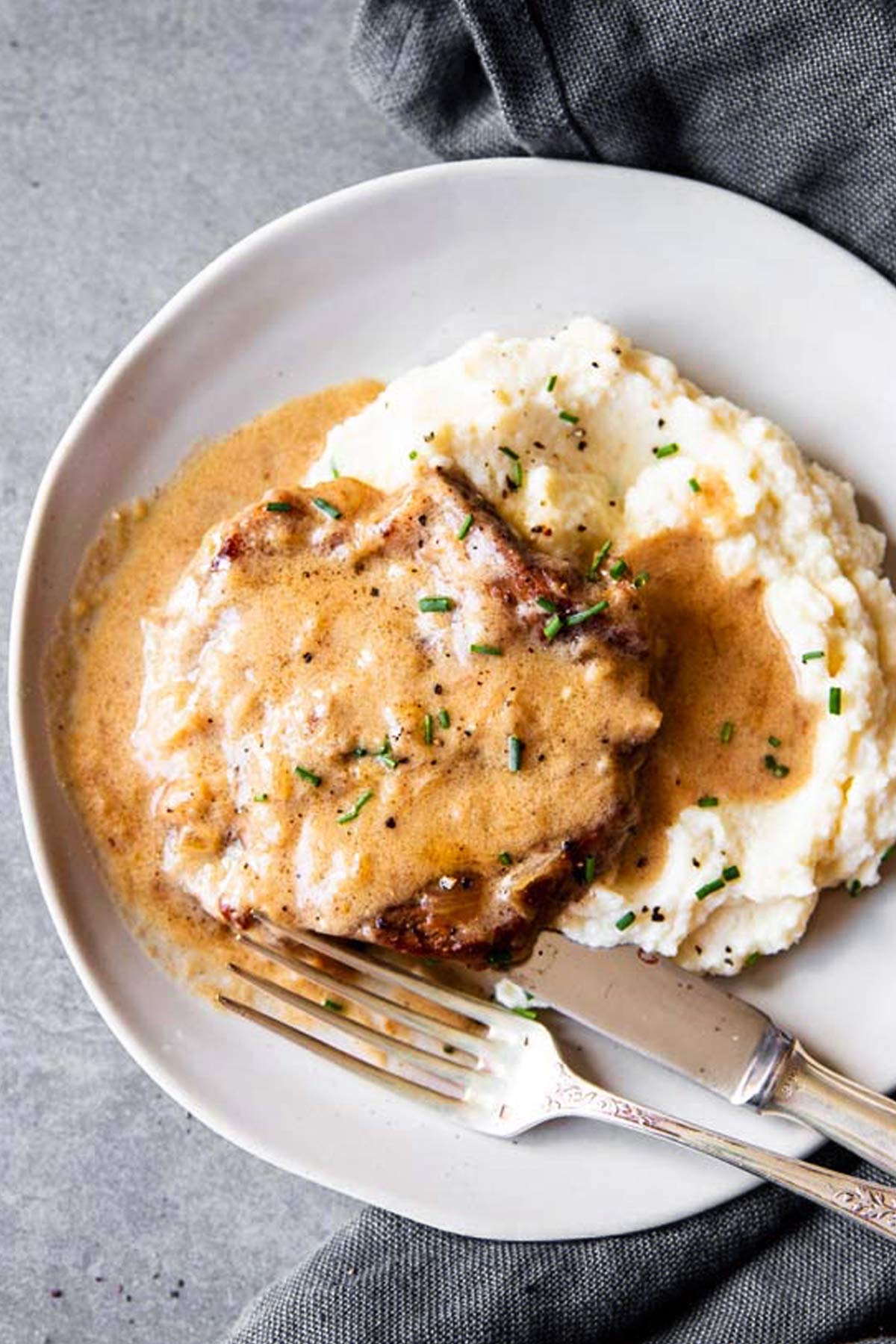 instant pot sour cream pork chop on a plate with mashed cauliflower