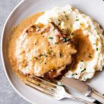 instant pot sour cream pork chop on a plate with mashed cauliflower