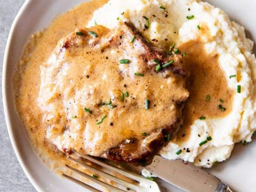 instant pot sour cream pork chop on a plate with mashed cauliflower