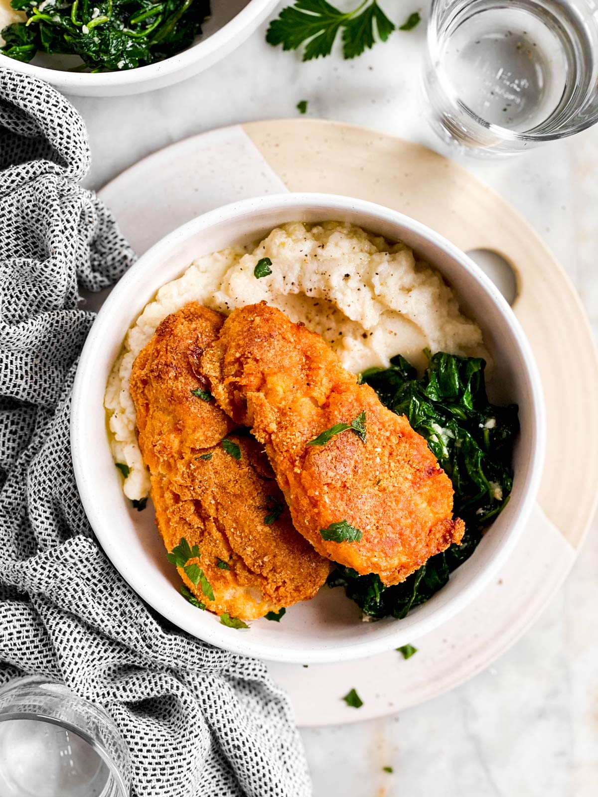 bowl with mashed cauliflower, sautéed spinach and low carb oven fried fish