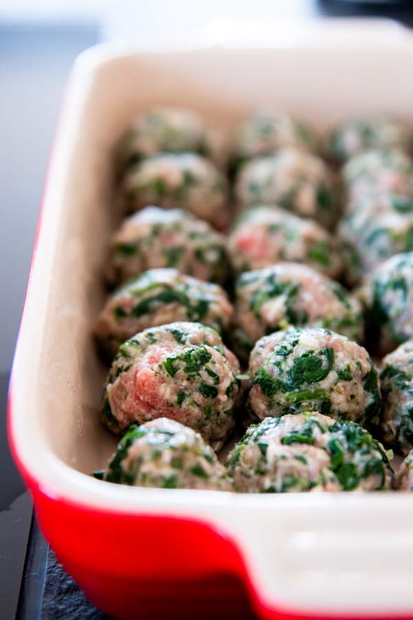 uncooked meatballs in a casserole dish