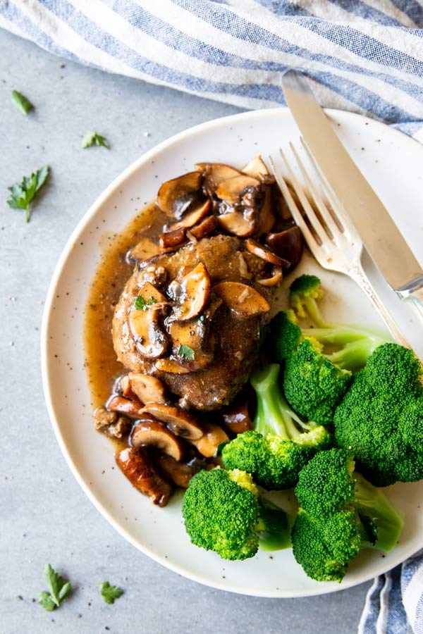 salisbury steak with mushroom gravy on a plate with broccoli