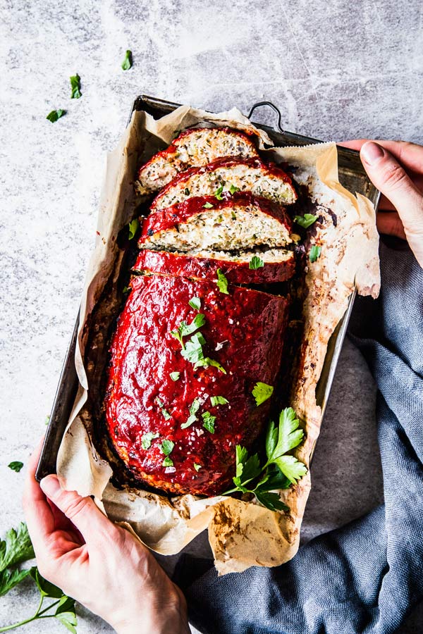 holding a tray with greek turkey meatloaf