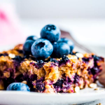 slice of blueberry baked oatmeal topped with fresh blueberries