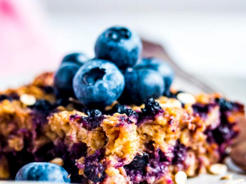 slice of blueberry baked oatmeal topped with fresh blueberries