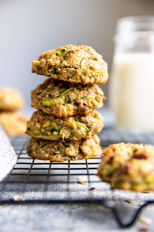 Four Zucchini Bread cookies stacked on top of a cooling rack.