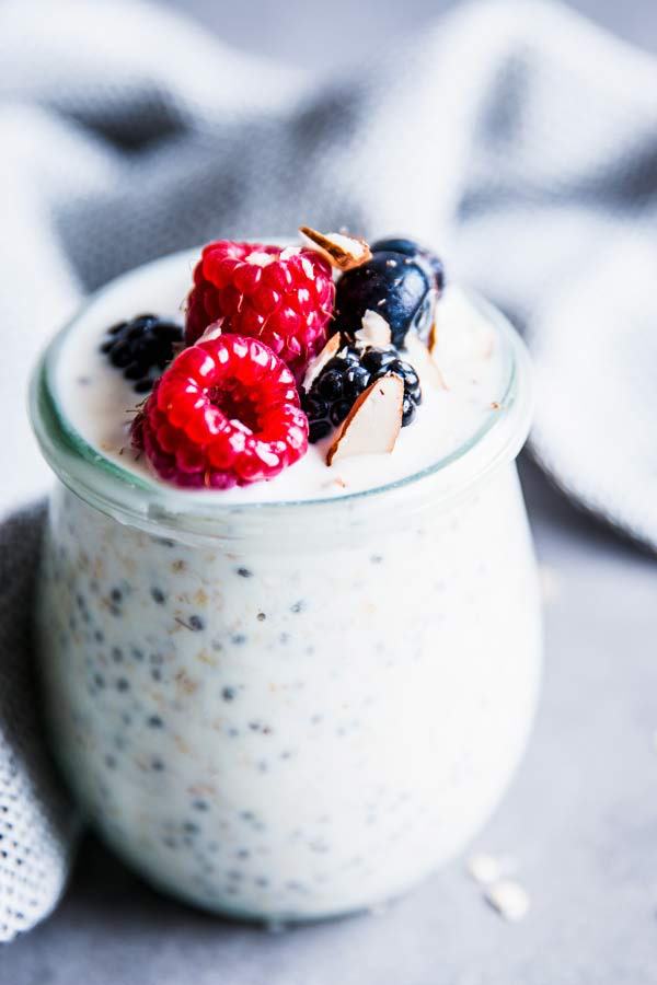 close up photo of a jar of overnight oats with berries