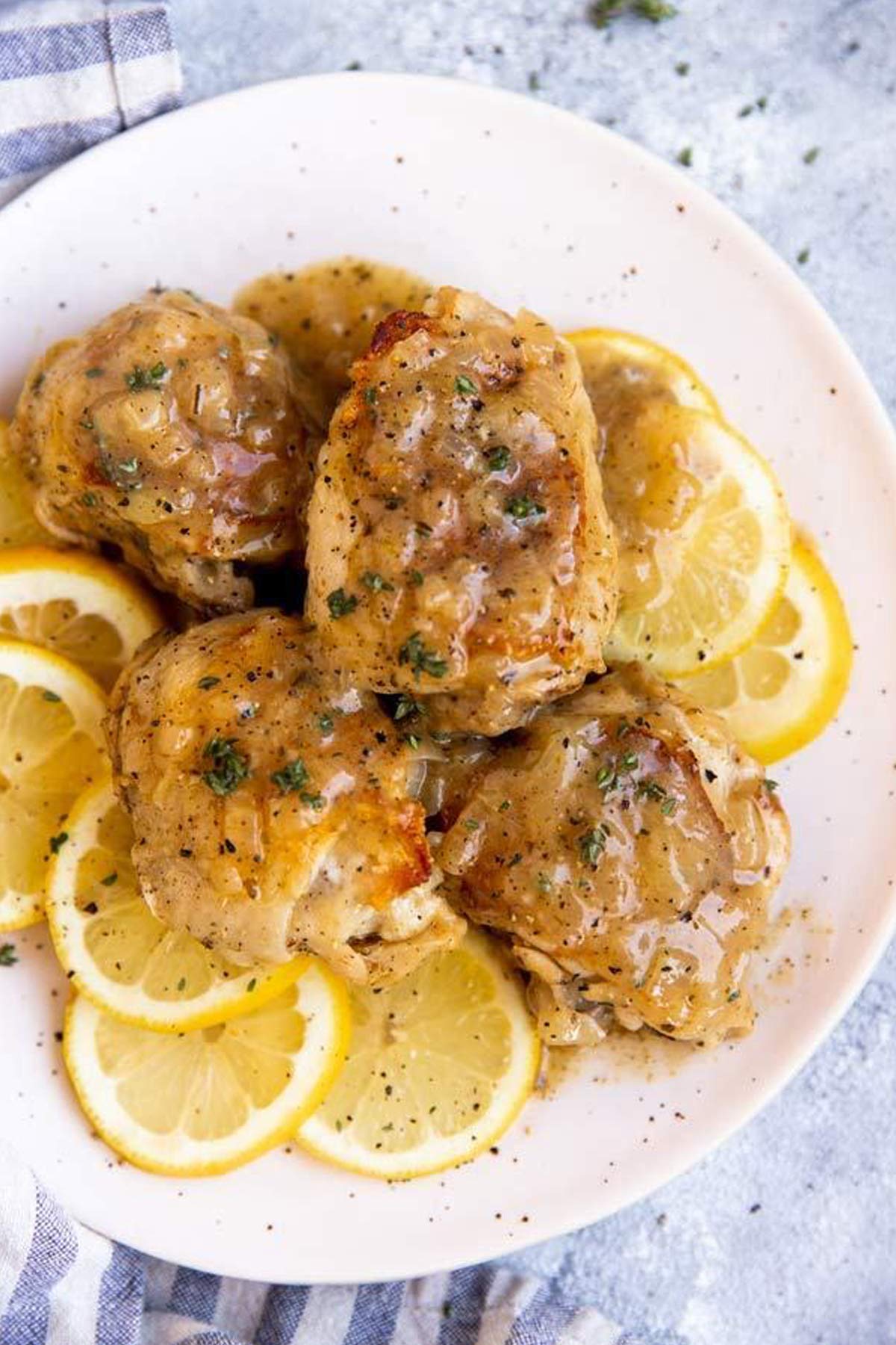 plate with lemon chicken and fresh lemon slices