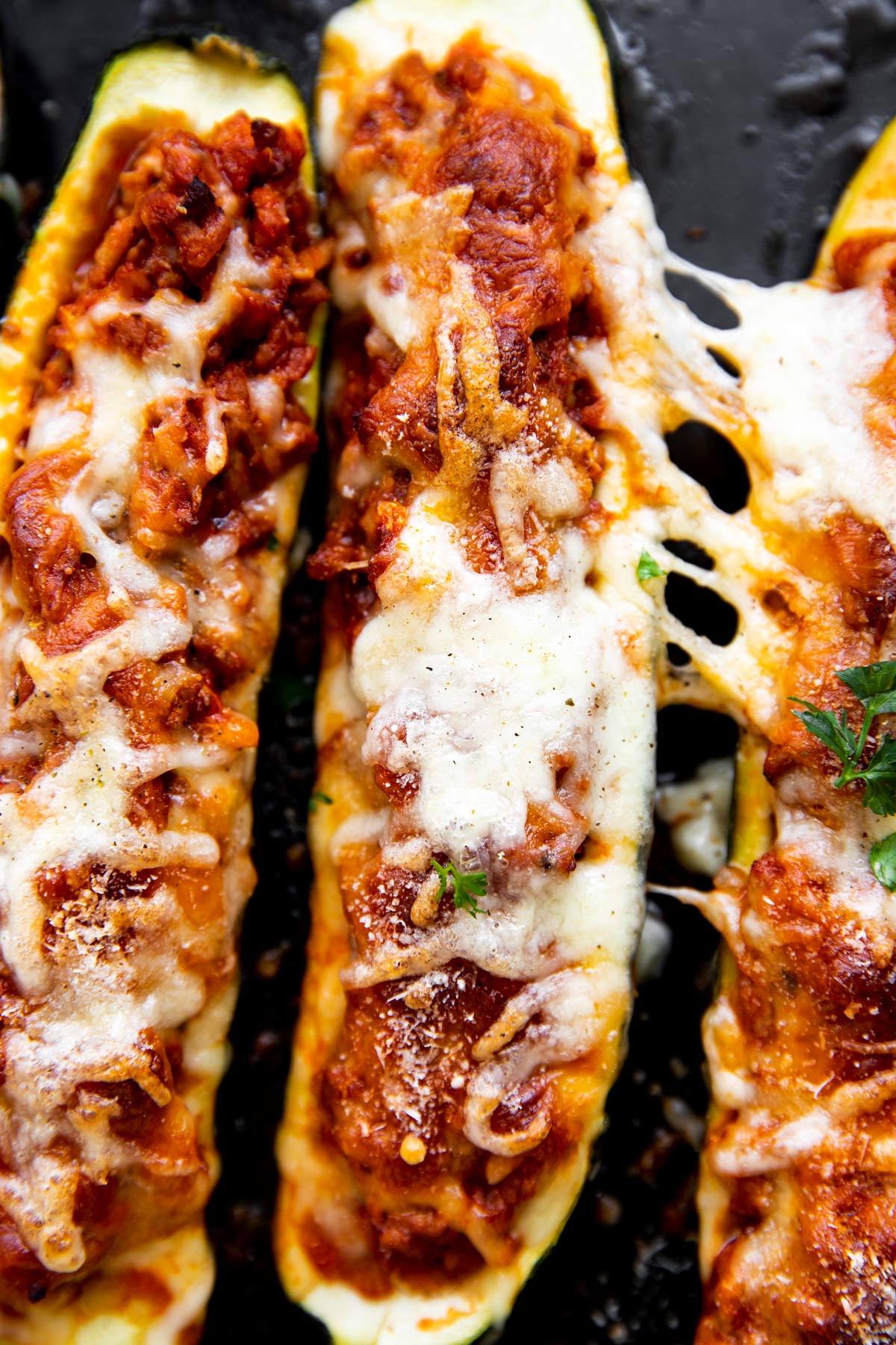 close up photo of melted cheese on stuffed zucchini