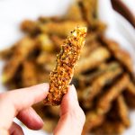 female hand holding a zucchini fry