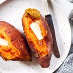 overhead view of two steamed sweet potatoes on a white plate
