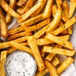 overhead view of air fryer French fries on line pan with ranch dip