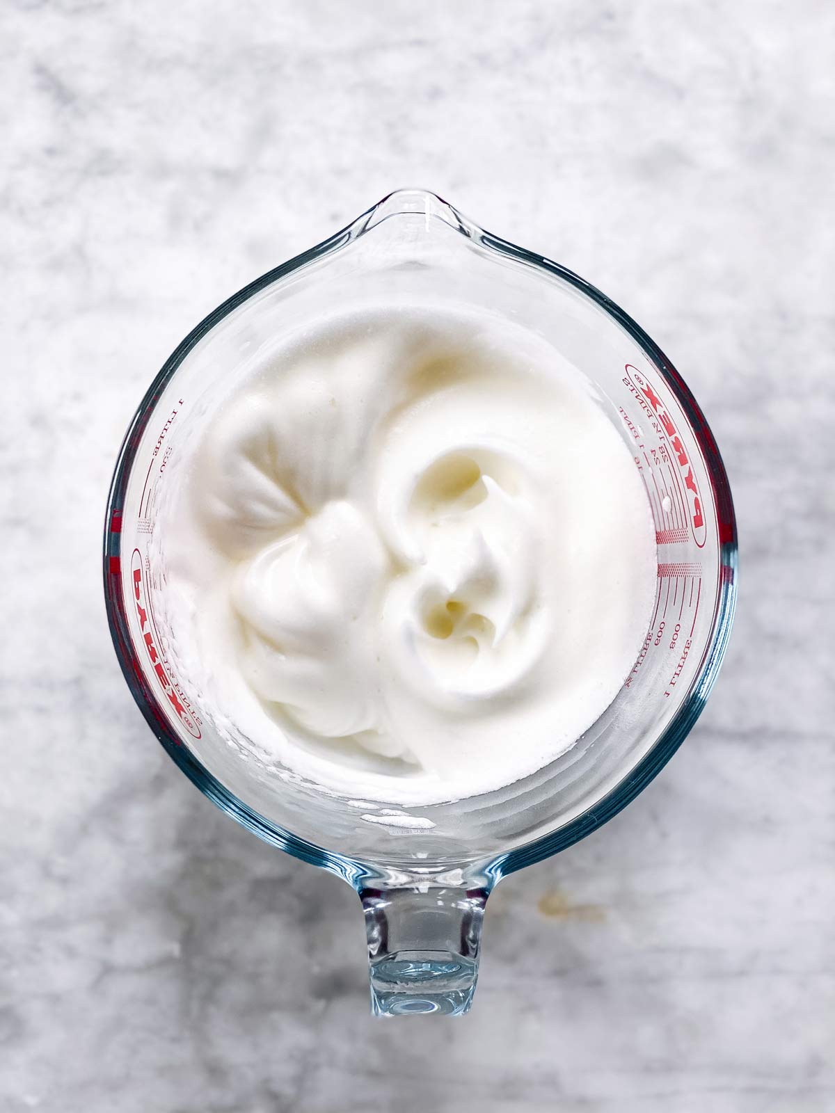 beaten egg whites in glass measuring jug