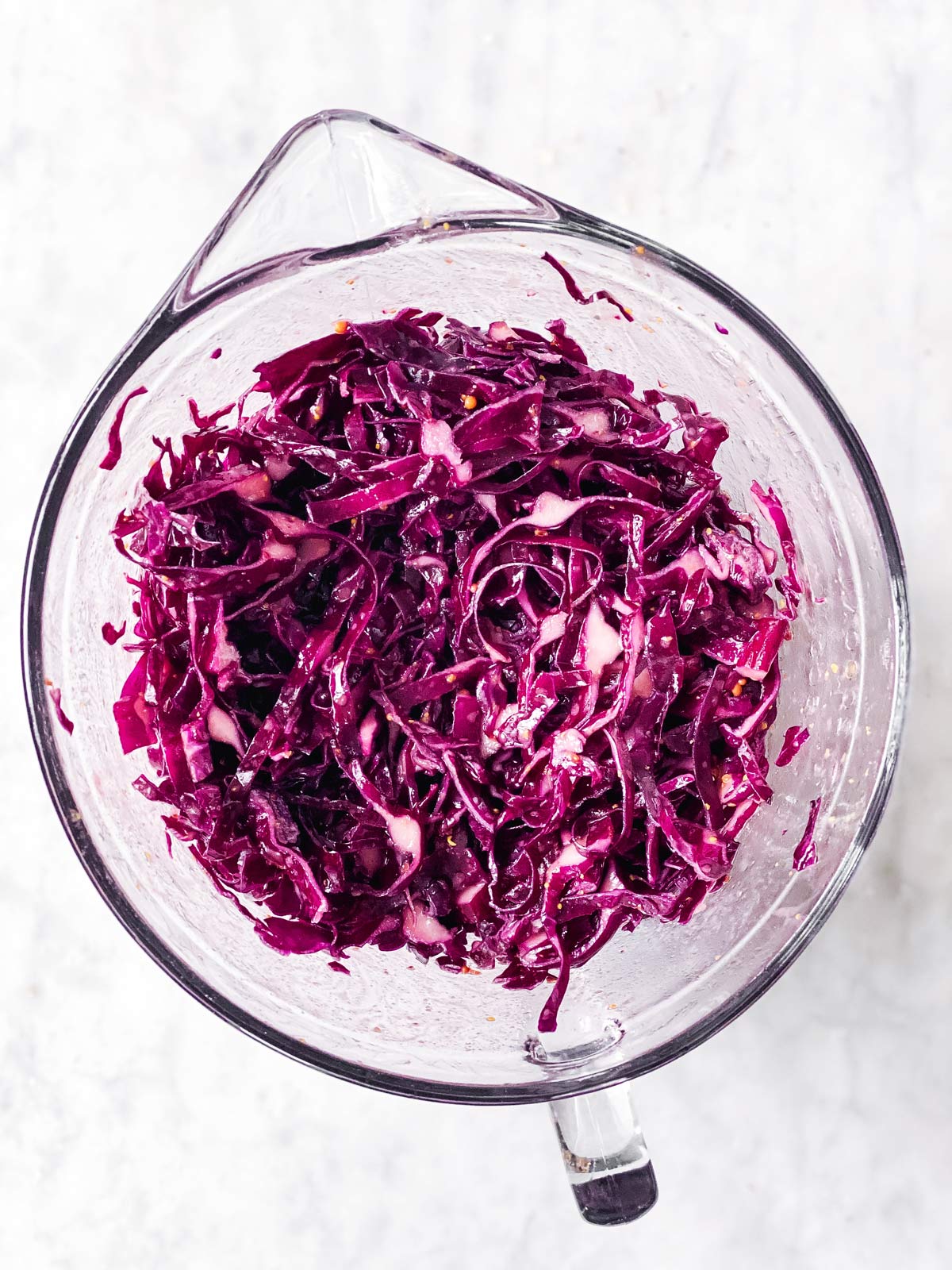 massaged shredded red cabbage in glass bowl